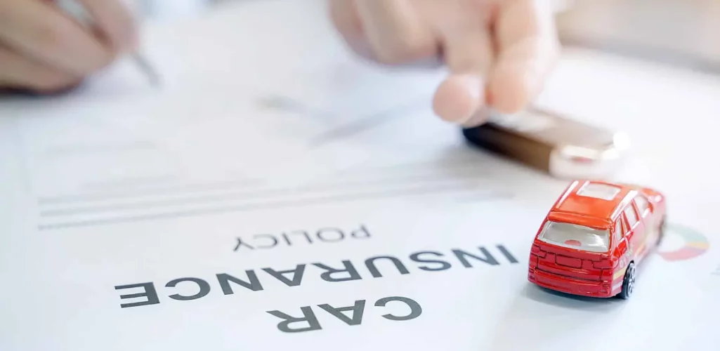 A person signing a car insurance policy in Tulsa, OK.