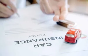 A person signing a car insurance policy in Tulsa, OK.