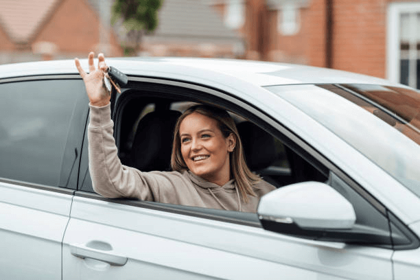 A woman is sitting in a car with a CDL, holding a key.