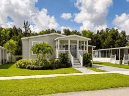 A manufactured home with a porch and a lawn in Arkansas