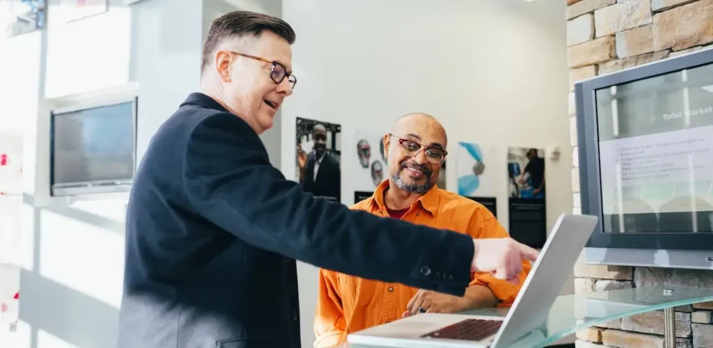 a man pointing at a laptop