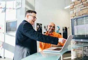 a man pointing at a laptop