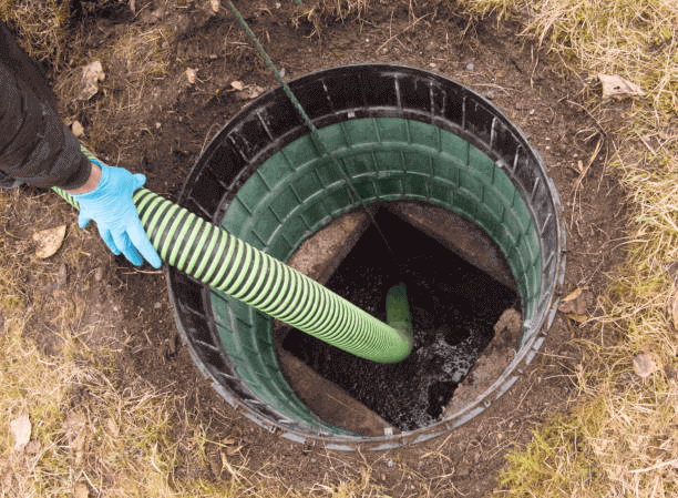 a person holding a hose in a hole