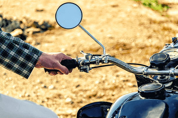 a hand holding a handlebar on a motorcycle