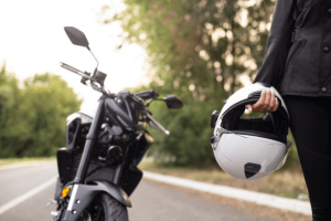 a person holding a helmet next to a motorcycle