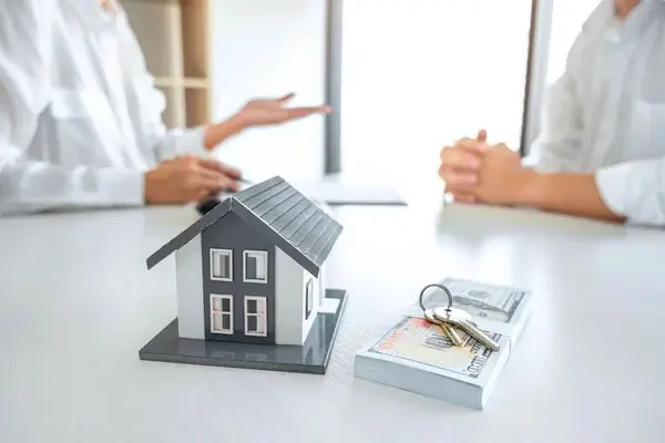a house model and keys on a table