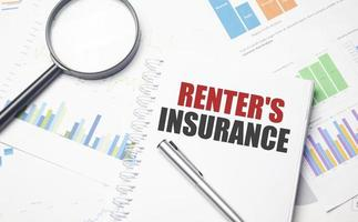 a pen and magnifying glass on a notebook about renters insurance