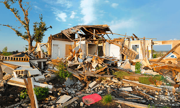 a house with debris on the ground because of a tornado