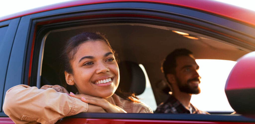 Smiling couple driving a car covered by affordable insurance in Little Rock, AR.