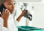 a woman taling on a phone about a plumbing issue