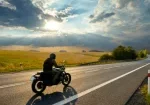 a man riding a motorcycle on a road