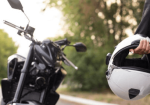 a person holding a helmet next to a motorcycle