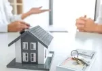 a house model and keys on a table